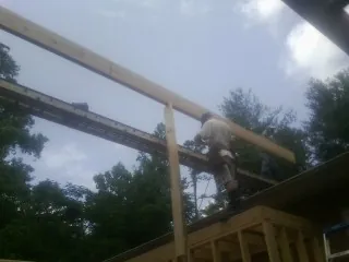 Carpenter setting a ridge beam over a new addition frame — Ice Dam Removal by Roofing Brothers in Lidgerwood