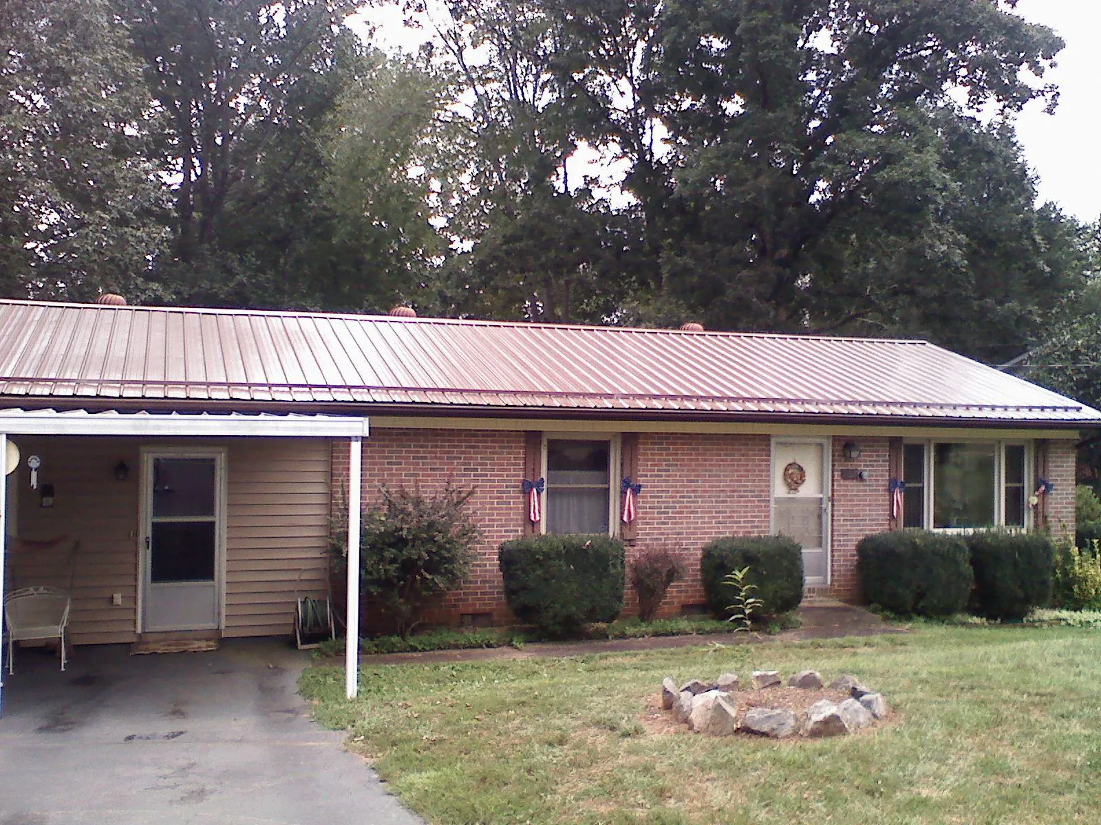 Bronze metal roof and carport on a brick ranch home — Roof Repair work by our crew in Lidgerwood